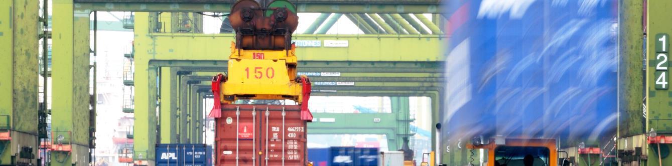 Container being lifted by a straddle carrier at a terminal